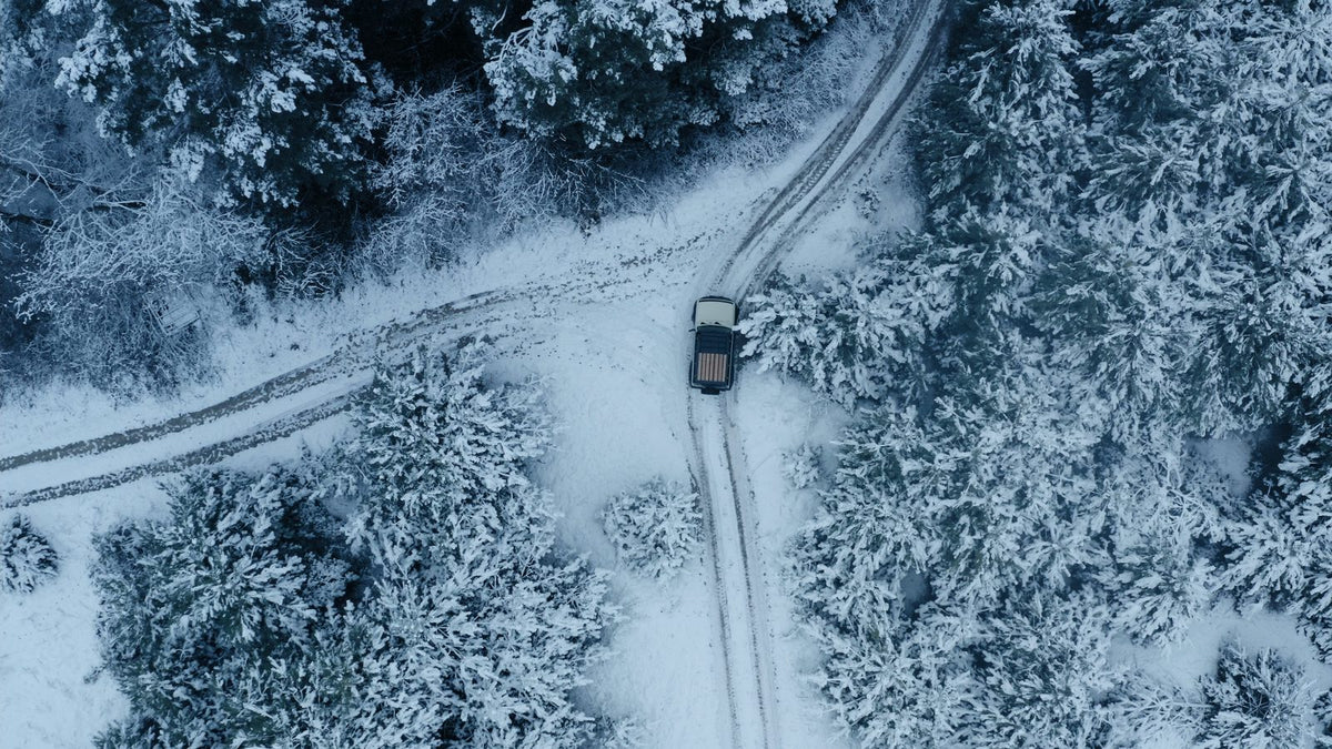 航拍:汽車駛過積雪森林小路