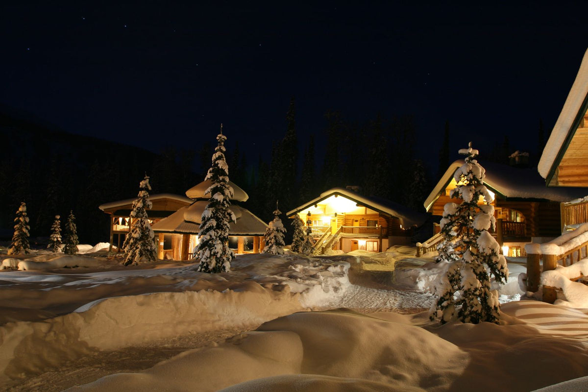 夜晚雪地中亮燈的木屋